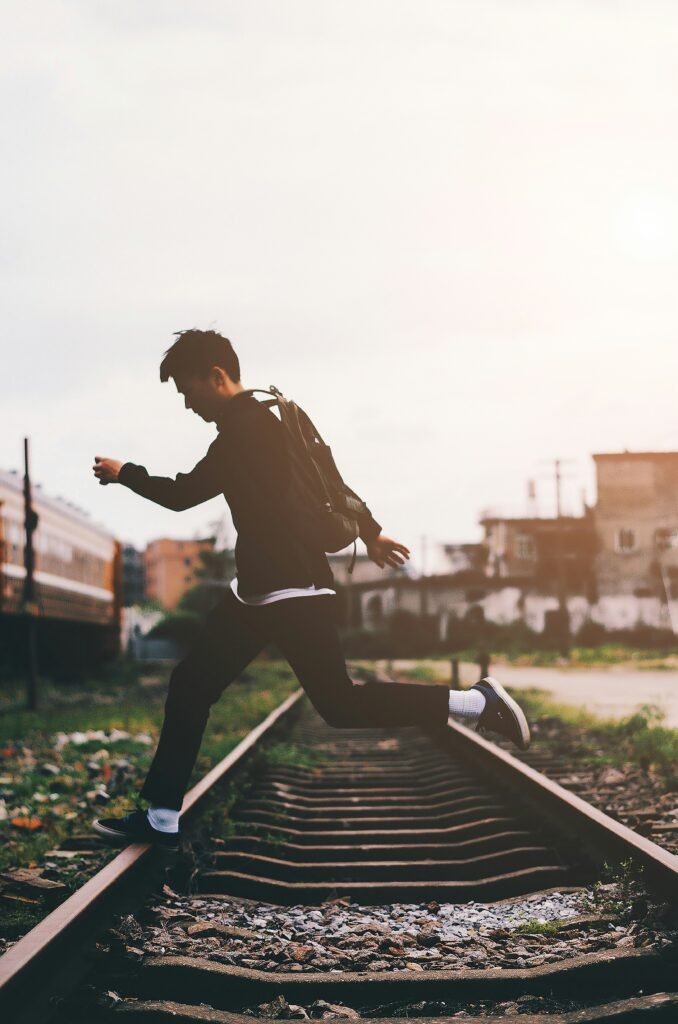 man crossing train track